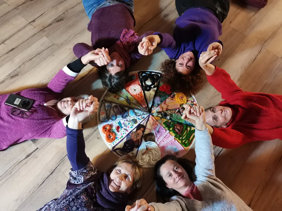 Cercle de femmes réunies au sol, vue plongeante