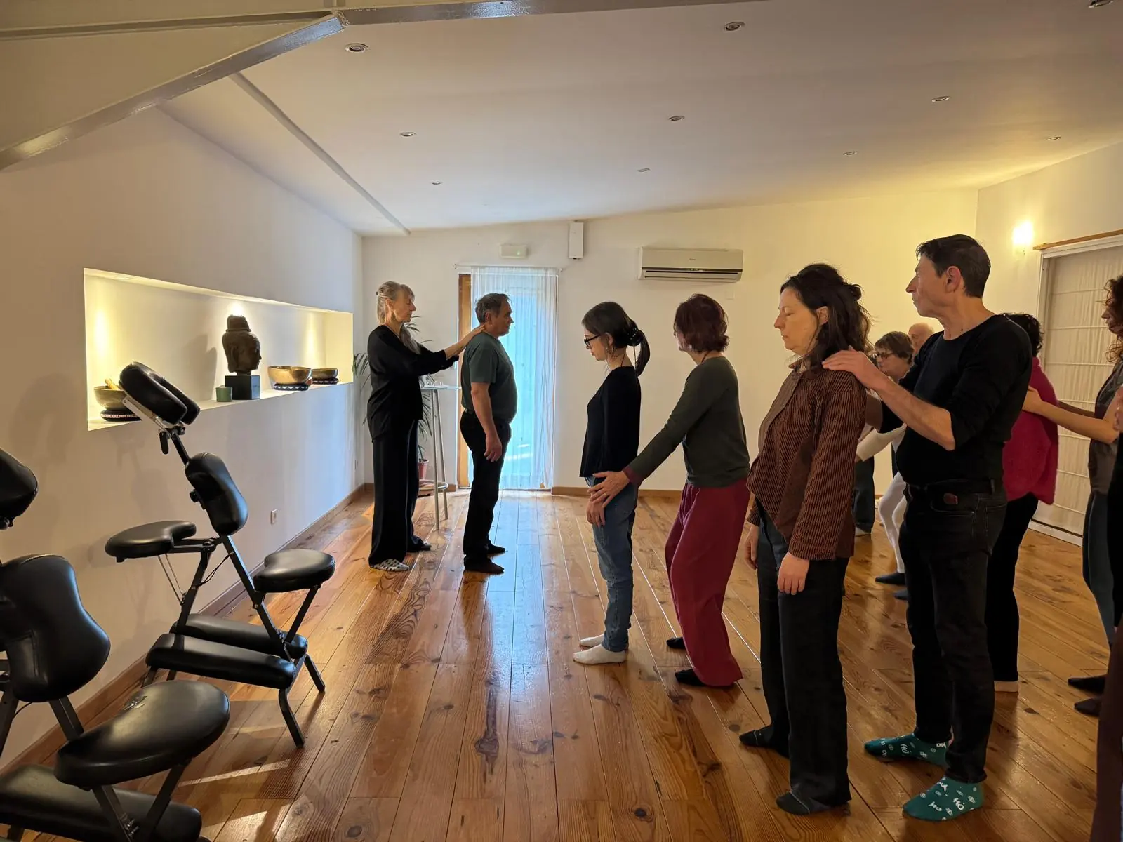 Un atelier de massage en groupe : les participants posent les mains sur les épaules de la personne devant eux