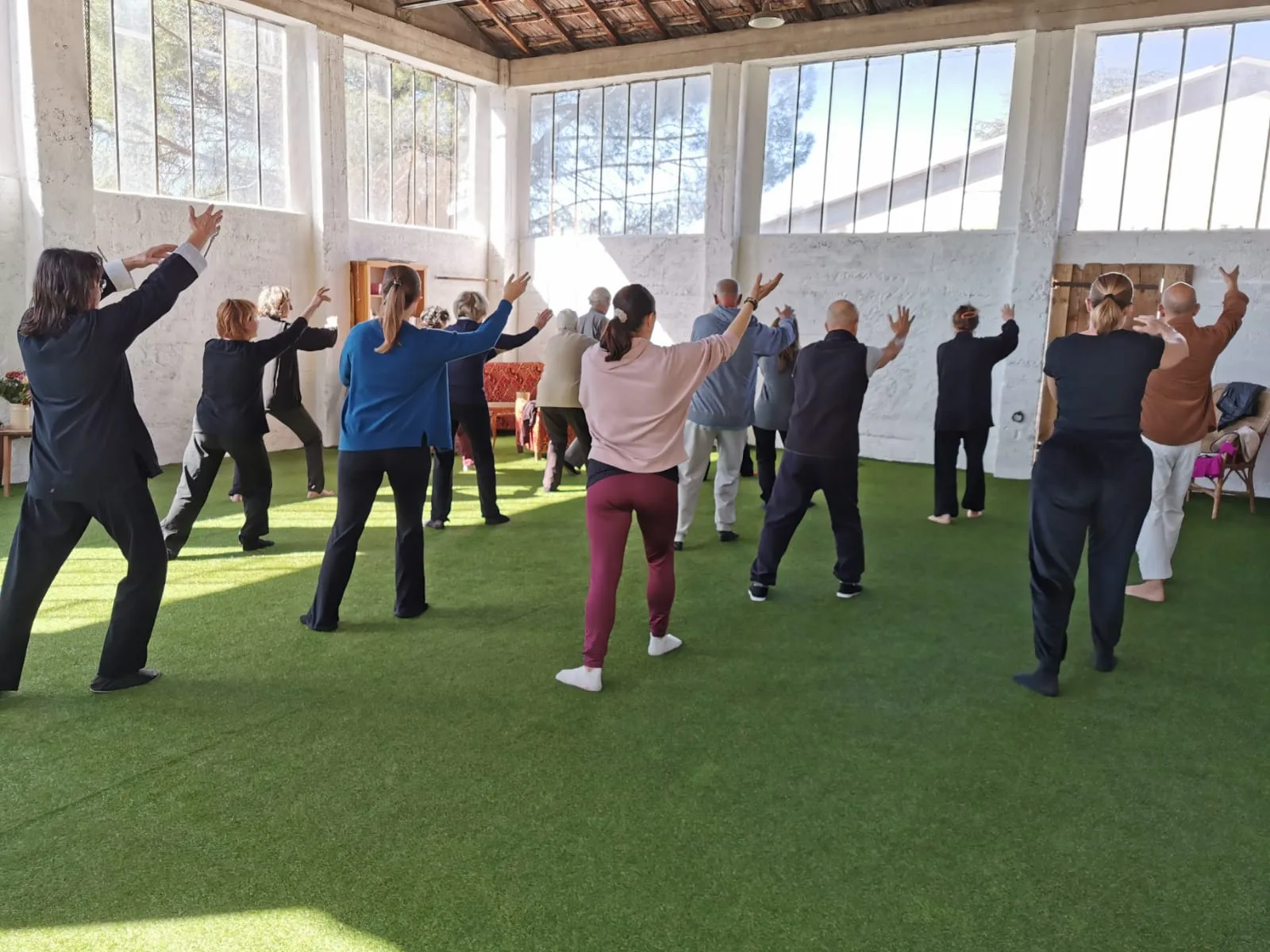 Un cours de Qi Gong en groupe, les bras levés
