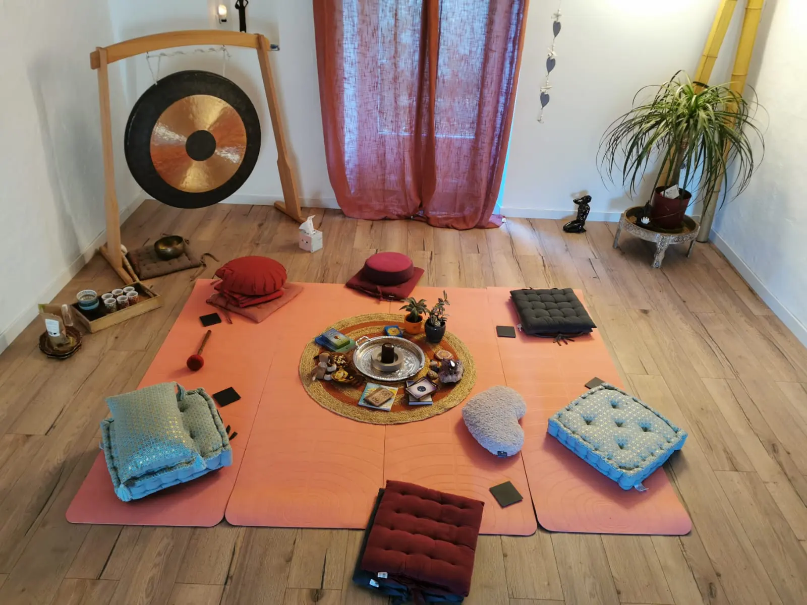 La salle blanche au gong, coussins et tapis disposés en cercle